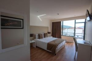 a hotel room with a bed and a large window at Hotel Quinta do Viso in Miranda do Corvo