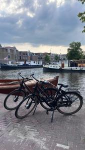 twee fietsen geparkeerd naast een rivier met boten bij The Harbour Leiden in Leiden