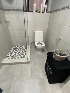 uma casa de banho com um chuveiro, um WC e uma caixa preta em Elite Stays em Gaborone