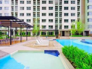 a swimming pool in front of a large building at studio room seaview jomtien in Jomtien Beach