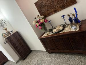 a wooden cabinet with a vase of flowers on it at Da Gio in Olbia