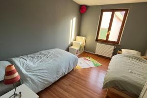 - une chambre avec 2 lits et du parquet dans l'établissement Grand appartement à Barr, à Barr