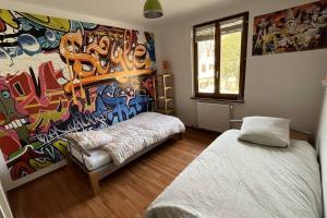 Cette chambre comprend deux lits et un tableau mural. dans l'établissement Grand appartement à Barr, à Barr