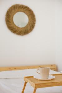 a coffee cup on a wooden table with a mirror at Le Péruvien - Saint-Cyr-L'Ecole - Free Parking in Saint-Cyr-lʼÉcole