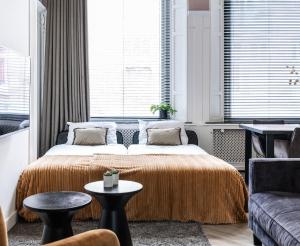 a bedroom with a bed and a couch at Luxious Apartment Wilhelmina in Tilburg