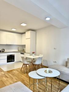 a living room with two tables and a couch at Golden Apartment in Skopje