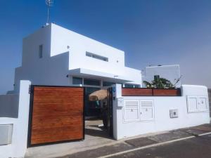 uma casa branca com portas de madeira em frente em Paisaje Lunar em Tinajo