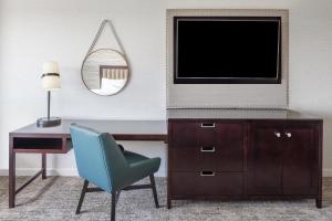 een kamer met een bureau, een tv en een stoel bij The Westin Baltimore Washington Airport - BWI in Linthicum Heights