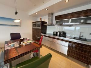 a kitchen with a wooden table and a dining room at Beachside 2-Zimmer-Meerblick-Appartement in Lübeck