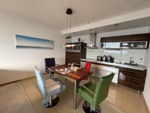 a kitchen and dining room with a table and chairs at Beachside 2-Zimmer-Meerblick-Appartement in Lübeck