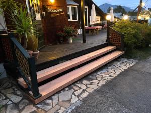 une terrasse en bois à l'extérieur d'une maison ornée de plantes dans l'établissement Lake village donaludo Pension, à Kitashiobara