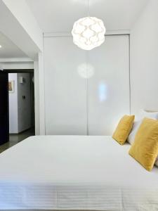 een slaapkamer met een groot wit bed met gele kussens bij VR2 Central Apartment in Boekarest