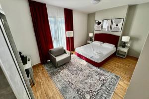 een slaapkamer met een bed, een stoel en een raam bij Hotel Fantazia Oradea - Self Check In & Out in Oradea