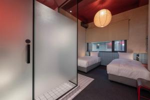 1 dormitorio con 2 camas y puerta corredera de cristal en Rotel Boutique Hotel, en Kutaisi