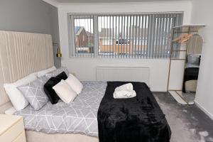 a bedroom with a bed and a large window at 3 Bedroom House Manchester Free Wifi and Parking in Manchester