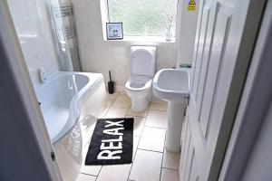 a bathroom with a toilet and a tub and a sink at 3 Bedroom House Manchester Free Wifi and Parking in Manchester