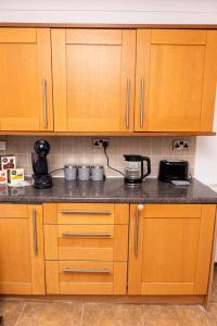 a kitchen with wooden cabinets and a counter top at 3 Bedroom House Manchester Free Wifi and Parking in Manchester