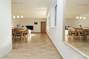 un miroir reflétant une salle à manger avec des tables et des chaises dans l'établissement Apartmen centrum Trnava, à Trnava