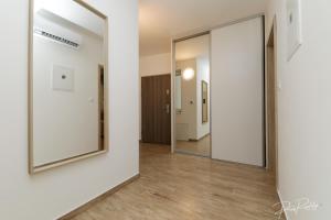 un couloir avec un miroir et des murs blancs dans l'établissement Apartmen centrum Trnava, à Trnava