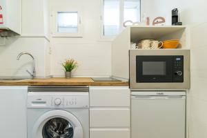 een keuken met een wasmachine en een magnetron bij Precioso apartamento en el centro recién reformado in Santander