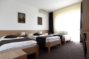 um quarto de hotel com três camas e uma janela em TIM rooms em Velika Gorica