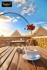 una taza de café y un jarrón con una flor en una mesa en Comfort Sphinx&Pyramids Inn en El Cairo