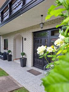 uma porta preta numa casa com flores brancas em Vila Jevtić studio 3 em Soko Banja