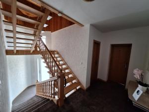 Una escalera de madera en una habitación con puerta en Home B&B, en Kaunas