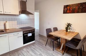 een keuken met een houten tafel en een eetkamer bij Ilmpartment Deluxe Suite - Vollausstattung - Boxspringbett - Wi-Fi - Netflix in Ilmenau