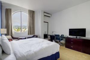 a hotel room with a bed and a large window at Commodore Suites in Simpson Bay