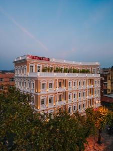 a white building with a sign on top of it at TRIBUTE Hotel in Shkodër