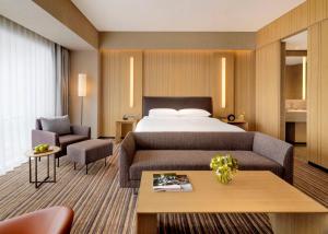 pokój hotelowy z łóżkiem i 2 krzesłami w obiekcie Hyatt Regency Beijing Wangjing w Pekinie