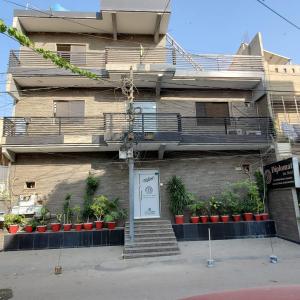 a building with a sign in front of it at Diplomat Inn Hotel in Karachi