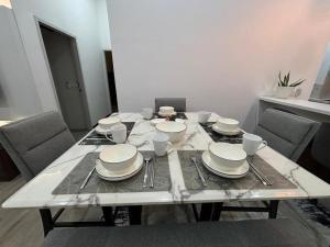 uma mesa com pratos e copos em cima em ANNA AR ANTARA RESIDENCE LAKE VIEW, Putrajaya em Putrajaya