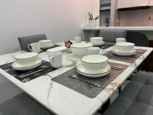 uma mesa com pratos e copos em cima em ANNA AR ANTARA RESIDENCE LAKE VIEW, Putrajaya em Putrajaya