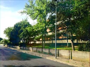 eine Straße mit einem Zaun und Bäumen an der Seite einer Straße in der Unterkunft Appartamento Velocipede in Cervignano del Friuli