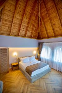 a bedroom with a large bed and a wooden ceiling at Boutique Hotel Vila 101 in Tirana