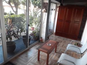 een veranda met een tafel en 2 stoelen en een raam bij Apartamento en Atlántida, A una cuadra de la Playa y 2 calles del Centro Excelente ubicación in Atlántida