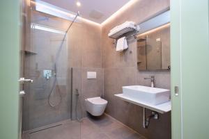 a bathroom with a shower and a toilet and a sink at Boutique Hotel Vila 101 in Tirana