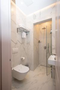 a white bathroom with a toilet and a shower at Boutique Hotel Vila 101 in Tirana