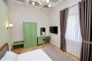 a bedroom with a green cabinet and a desk at Boutique Hotel Vila 101 in Tirana