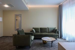 a living room with a couch and chairs and a table at Suncity Hotel & SPA in Šiauliai