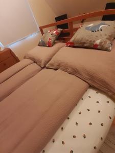 um quarto com 2 camas individuais e uma colcha com uma almofada de tubarão em Mókuska erdőszéli faházikó em Parád