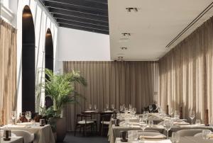 a dining room with white tables and chairs at Hotel Portinari in Bruges