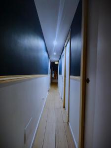 a hallway with blue walls and a long hallway with wooden floors at BIG FLAT - LE CALA - Hypercentre - 4 chambres, 13 personnes, proche plage gare et parking, WIFI, Air Conditioning l GROUPE l BUSINESS l FAMILLE in Nice