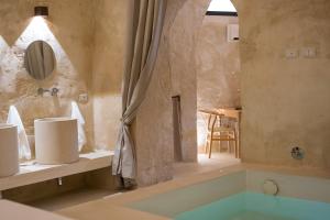 un bagno con vasca e una camera con tavolo di Il Suq Lecce Luxury Apartment a Lecce