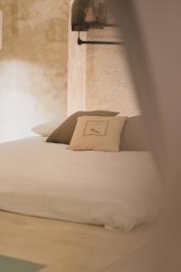 un letto bianco con un cuscino sopra di Il Suq Lecce Luxury Apartment a Lecce