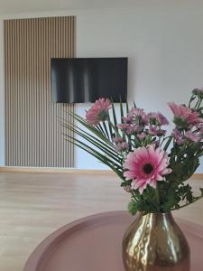 een vaas gevuld met roze bloemen zittend op een tafel bij Apartment Seeblick in Bad Salzungen