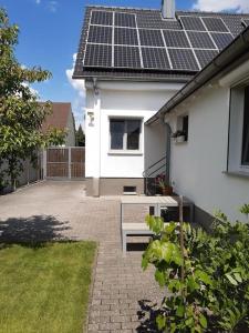 uma casa branca com painéis solares no telhado em Apartment mit Innenhof, Rasen und Parkplatz em Altlußheim