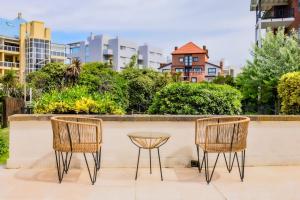 2 chaises et une table devant un mur dans l'établissement Victoria Village, à Carilo